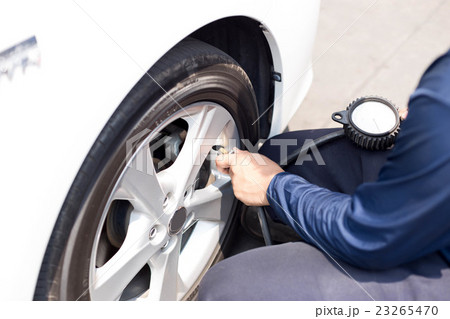 Man checking tire air pressure Man checking tire air pressure 23265470
