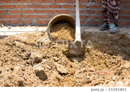 Construction workers putting sand in the bucket Construction workers putting sand in the bucket 23265801