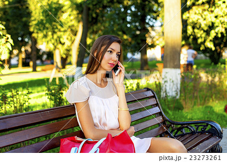Beautiful girl sitting on a bench, brunette in Beautiful girl sitting on a bench, brunette in 23273261