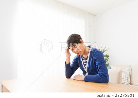 体調不良　頭痛　偏頭痛　男性　ポートレート　男の人　リビング　コピースペース 23275901