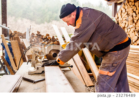 Carpenter working. Man cutting plank by circular Carpenter working. Man cutting plank by circular 23276489