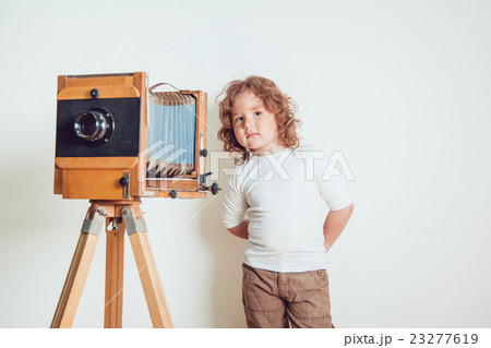 Little boy standing near the camera on a white Little boy standing near the camera on a white 23277619