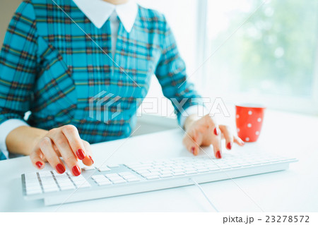Woman office worker typing on the keyboard 23278572
