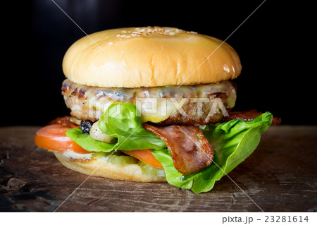 cheese burger on wood board over black background 23281614
