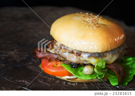 cheese burger on wood board over black background 23281615