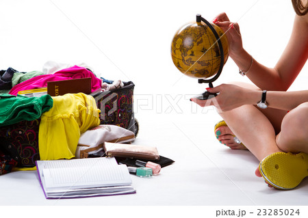 Lady sits beside filled suitcase. Lady sits beside filled suitcase. 23285024