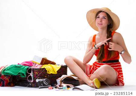 Sitting girl near overfilled suitcase. 23285114