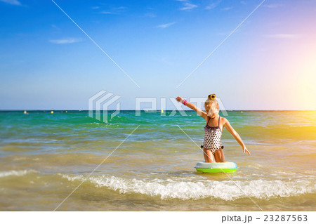 Cute girl in swimsuit bathes on waves in sea Cute girl in swimsuit bathes on waves in sea 23287563