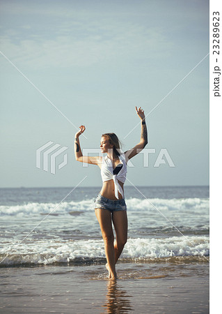 young pretty blond woman at seacoast walking 23289623