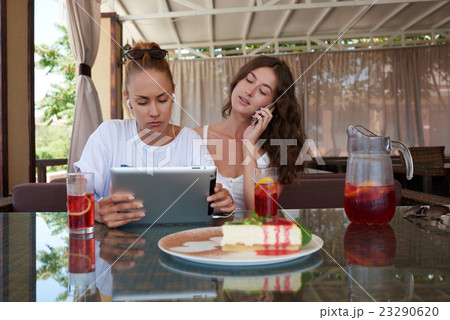 Ladies using touch pad and cell telephone  23290620
