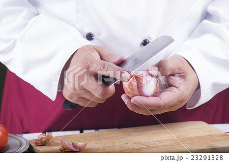 Chef peeling red onion with knife Chef peeling red onion with knife 23291328