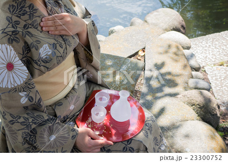 屋外　ぐい呑と日本酒との女性手元 23300752