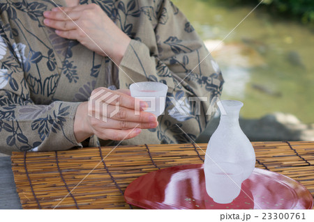 屋外　ぐい呑と日本酒との女性手元 23300761