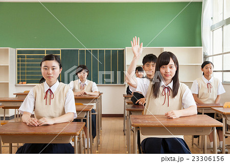 授業で手を挙げる女子生徒 23306156