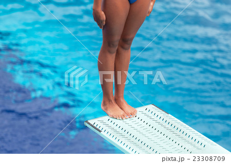 Girl standing on a springboard, preparing to dive 23308709