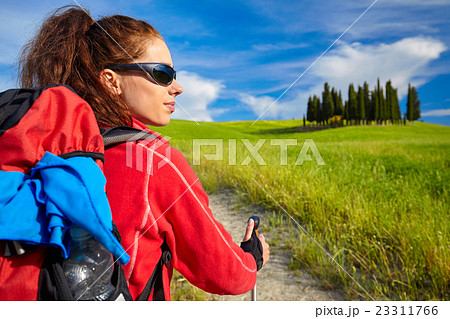 Tourist girl enjoying view of beautiful dry green wheat hills 23311766