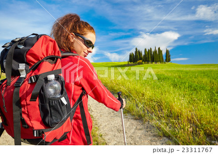 Tourist girl enjoying view of beautiful dry green wheat hills 23311767