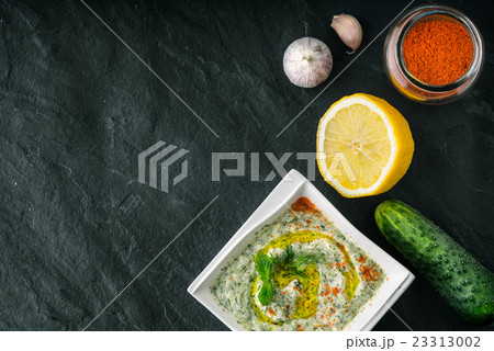 Tzatziki  on the  stone table with vegetables 23313002