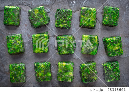 Cubes of frozen spinach on the stone table  23313661