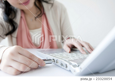 メモリースティックを挿すビジネスウーマンの手元 メモリースティックを挿すビジネスウーマンの手元 23320054