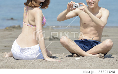 海で写真を撮る若いカップル 海で写真を撮る若いカップル 23321648