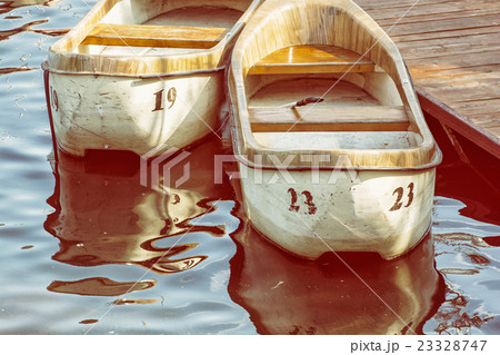 Two old boats at the pier, yellow photo filter 23328747