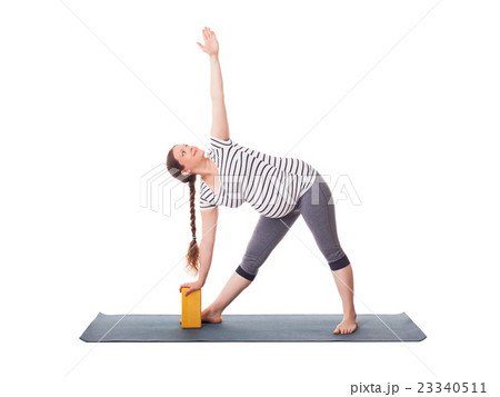Pregnant woman doing yoga asana Utthita 23340511