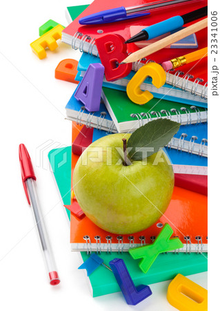 School supplies and green apple in foreground. 23341006