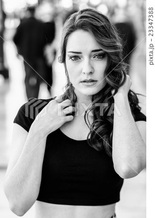 Beautiful young woman with blue eyes in urban background 23347388