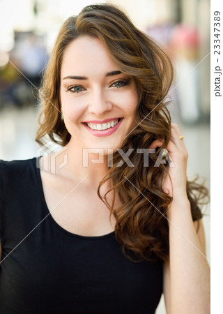 Beautiful young woman with blue eyes smiling in urban background 23347389