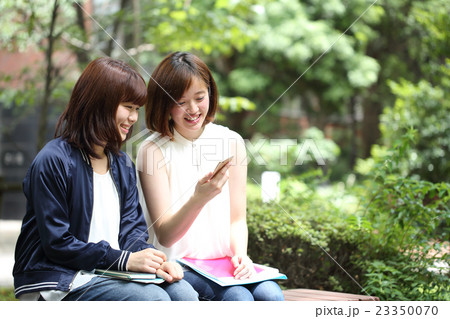 スマホを眺める女子大生の写真素材