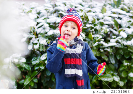Happy child having fun with snow in winter 23351668