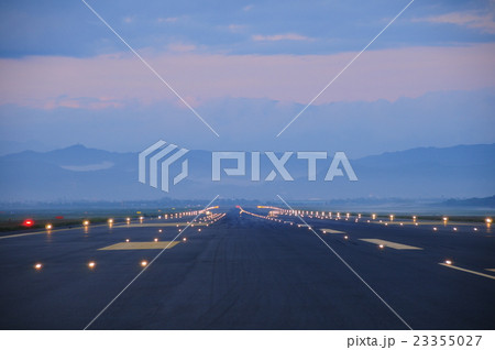 滑走路の誘導灯と空と山の風景の写真素材