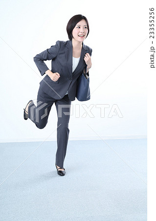 走るスーツを着た女性の写真素材