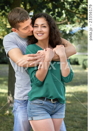 Romantic couple sit on grass in park, boy and girl 23356179