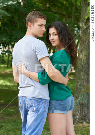 Romantic couple sit on grass in park, boy and girl 23356180