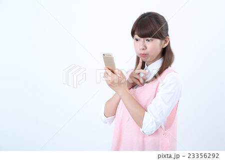 スマホをするエプロン姿の女性 23356292