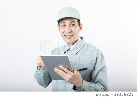 タブレットを操作する作業服の男性 23356825