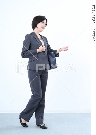 腕時計を見るスーツを着た女性 腕時計を見るスーツを着た女性 23357112