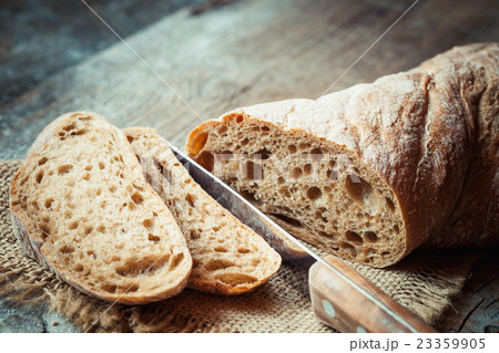 Fresh bread slice and cutting knife on table 23359905
