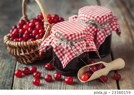 Jars of cranberries jam and basket 23360159
