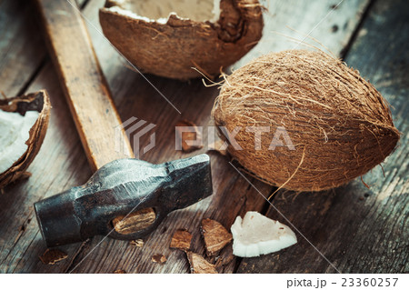 Coconuts and hammer on old wooden table Coconuts and hammer on old wooden table 23360257
