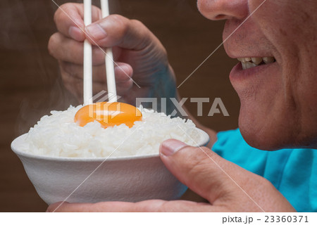 炊きたて温か卵かけご飯を食べるシニア 23360371