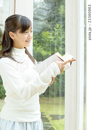 サンルームで読書しながら指差す女の子 23360863