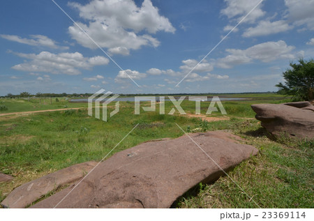 Brown sandstone and grass under beautiful cloudy s Brown sandstone and grass under beautiful cloudy s 23369114
