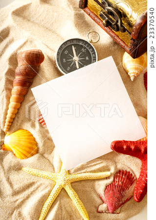 Seashells, compass and paper on sand Seashells, compass and paper on sand 23370540
