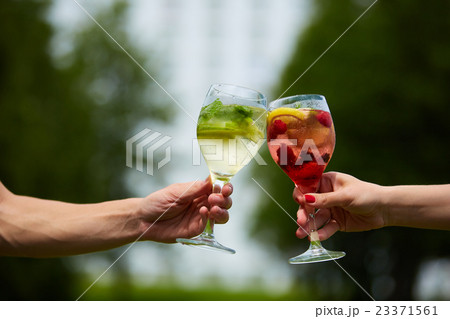 Hand holding glasses cocktail clinking together at 23371561