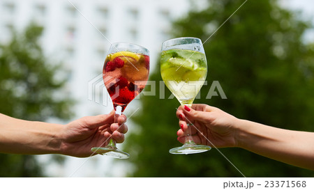 Hand holding glasses cocktail clinking together at 23371568
