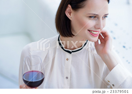 Happy businesswoman enjoying red wine 23379501
