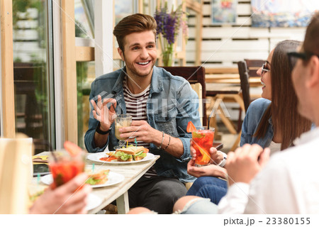 Happy friends having lunch in cafe Happy friends having lunch in cafe 23380155